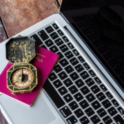 A compass sitting on a laptop keyboard.