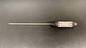 Lab Supplies Digital Thermometer A handheld digital thermometer with a long metal probe attached to a black and red plastic body featuring a small display screen. Alternative text created using Copilot and edited by a human on February 26, 2026.